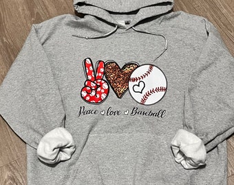 Könnte beinhalten: Grauer Kapuzenpullover mit einem Peace-Zeichen, einem Herzen und einer Baseball-Grafik. Der Text "Peace love baseball" ist unter der Grafik gedruckt.