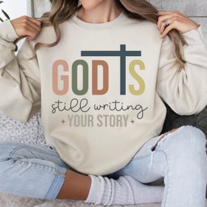 God Is Still Writing Your Story Boho Christian Sweatshirt Trendy Worship Sweatshirt Christian Clothes Catholic Gift Christian Women Crewneck