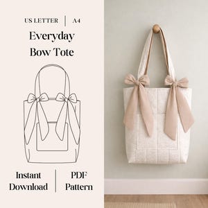 May include: A cream-colored tote bag with bow accents. The bag has a quilted texture and a front pocket. The handles and bows are a light tan color. The image also includes a line drawing of the bag and text that reads "Everyday Bow Tote".