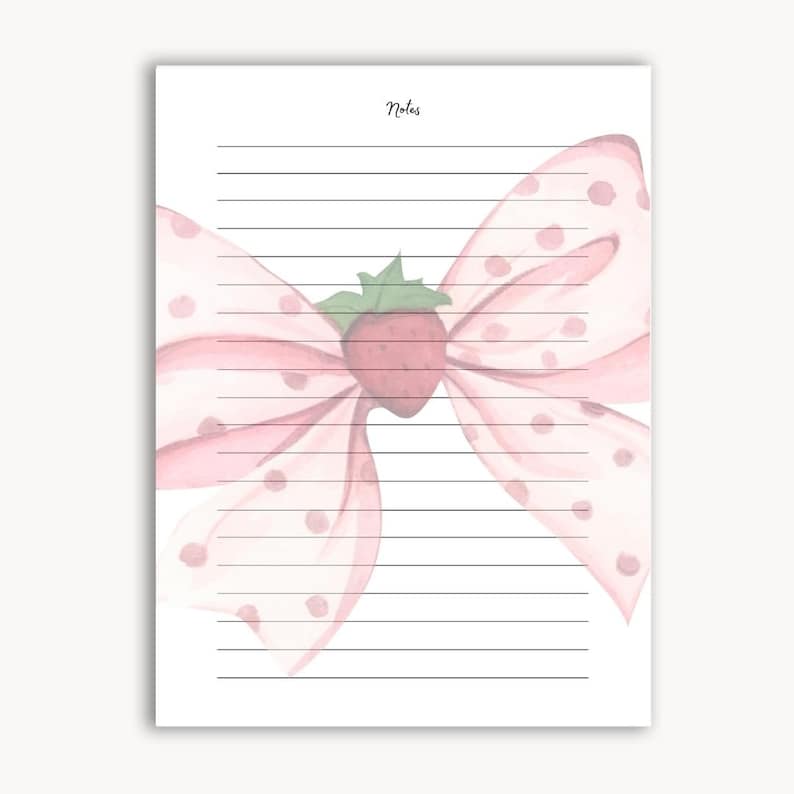 Peut inclure: Un bloc-notes lign&eacute; avec une illustration &agrave; l'aquarelle d'un n&oelig;ud rose &agrave; pois et d'une fraise au centre. Le mot "Notes" est &eacute;crit en cursive en haut. Le bloc-notes est sur fond blanc.