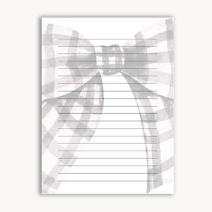 Peut inclure: Un bloc-notes lign&eacute; avec un motif aquarelle d'un n&oelig;ud vichy gris et blanc en haut. Le n&oelig;ud est centr&eacute; et occupe le tiers sup&eacute;rieur de la page. Les lignes sont noires et espac&eacute;es uniform&eacute;ment.