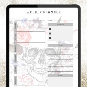 May include: Digital weekly planner displayed on a tablet. The planner features a skull design with floral accents in pink, red, and blue. The text "WEEKLY PLANNER" is at the top, with sections for each day, priorities, to-do, and notes.