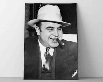 Op de afbeelding: Zwart-witfoto van een man met een witte fedora en een pak, die een sigaar rookt.