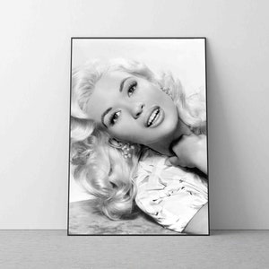 K&ouml;nnte beinhalten: Schwarzwei&szlig;-Portr&auml;tfotografie einer Frau mit blonden Haaren. Sie tr&auml;gt eine helle Bluse und l&auml;chelt.