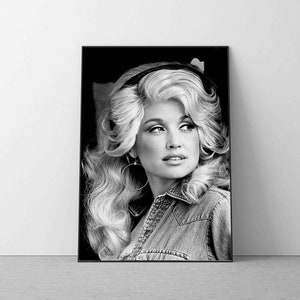 May include: Black and white portrait photograph of a woman with long blonde hair, wearing a denim jacket and large hoop earrings. She is looking off to the side with a slight smile.