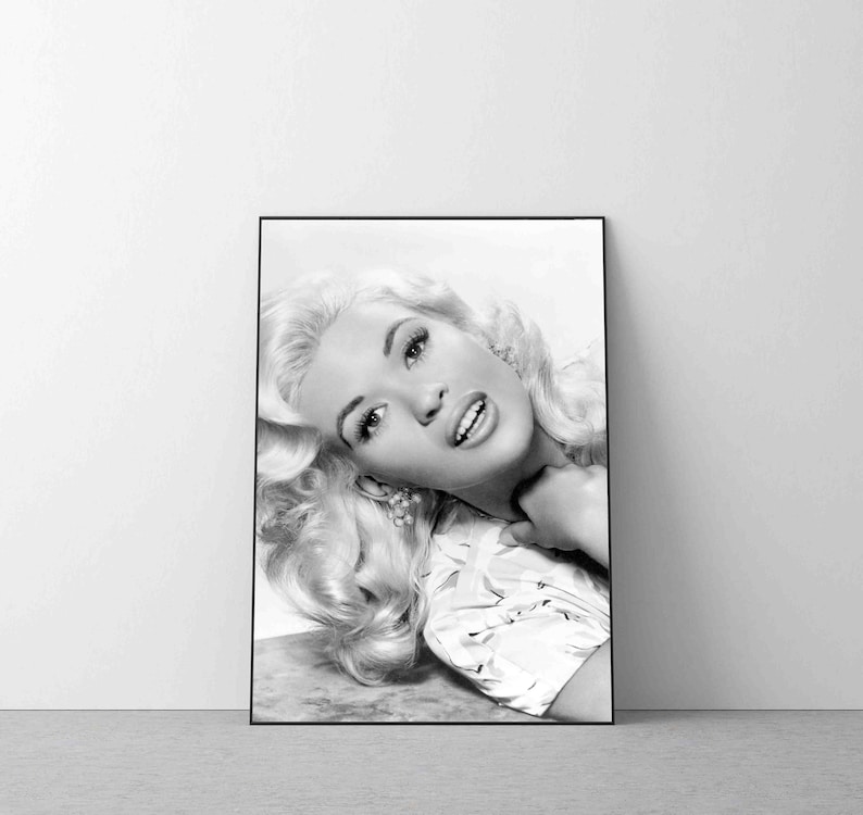 K&ouml;nnte beinhalten: Schwarzwei&szlig;-Portr&auml;tfotografie einer Frau mit blonden Haaren. Sie tr&auml;gt eine helle Bluse und l&auml;chelt.