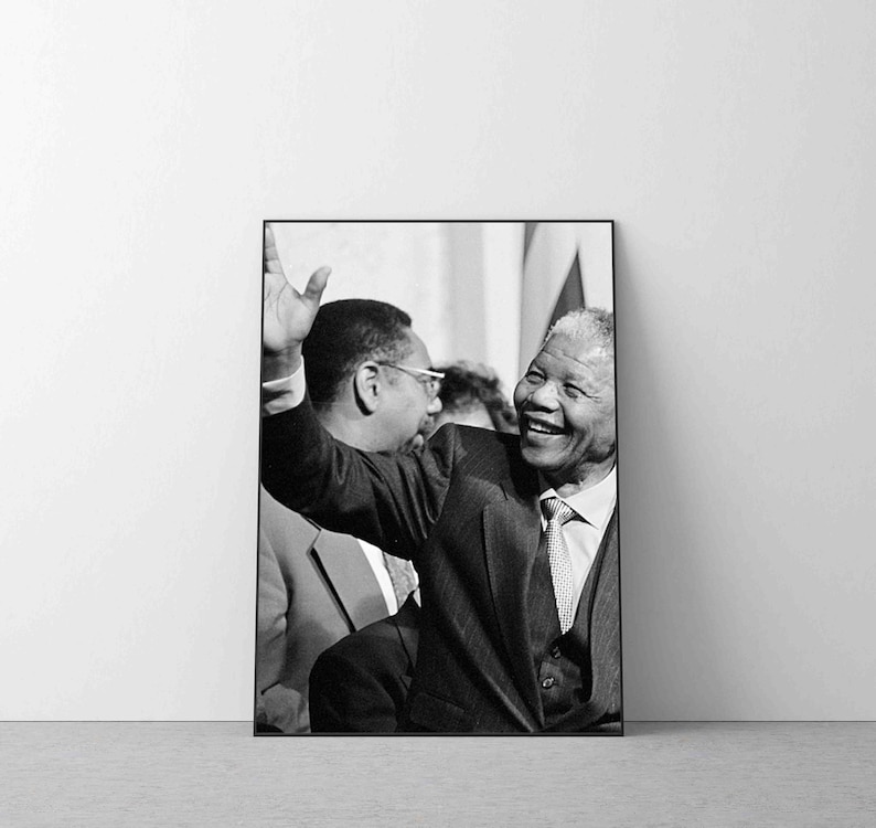 Puede incluir: Foto en blanco y negro de Nelson Mandela sonriendo y saludando, con otro hombre de pie a su lado.