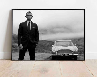 May include: A black and white photograph of a man in a suit standing in front of a classic car. The man is looking at the camera and the car is parked on a road with a foggy background. The car's license plate reads "BMT 216A".