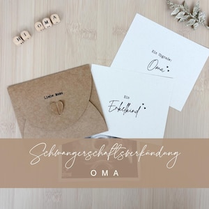 Op de afbeelding: Een verzameling aankondigingskaarten en een kraftpapieren envelop. De envelop is verzegeld met een hartvormig versiering en heeft de tekst "Liebe Mama" erop gedrukt. De kaarten hebben de tekst "Ein Enkelkind" en "Ein Upgrade: Oma:" .