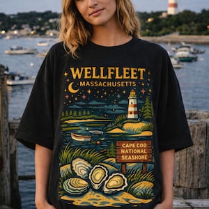 May include: Black t-shirt with a Wellfleet, Massachusetts design. The graphic depicts a lighthouse, ocean scene, oysters, and the text "Cape Cod National Seashore". The design uses blue, green, and yellow.
