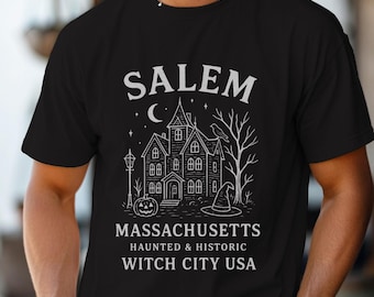 May include: Black t-shirt with a white graphic of a haunted house, a crescent moon, and stars. The text reads "SALEM MASSACHUSETTS HAUNTED & HISTORIC WITCH CITY USA". Features a jack-o'-lantern, a witch's hat, and a bare tree.