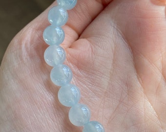 Pode incluir: Um bracelete de pedras preciosas azul claro com contas redondas.