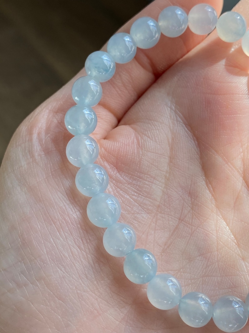 K&ouml;nnte beinhalten: Ein hellblaues Edelstein-Armband mit runden Perlen.