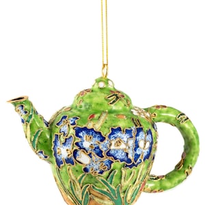 May include: A green teapot Christmas ornament with blue and white floral details and gold accents. The ornament has a loop for hanging.