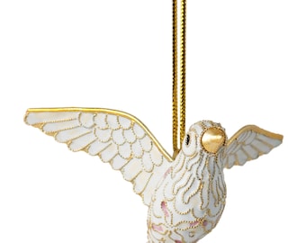 May include: White dove Christmas ornament with gold accents and pink details. The dove is in flight with its wings spread out. The ornament has a gold string for hanging.