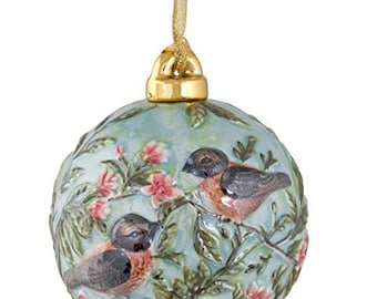 May include: A blue and green Christmas ornament with a floral design and two birds. The birds are painted in shades of brown, red, and black.