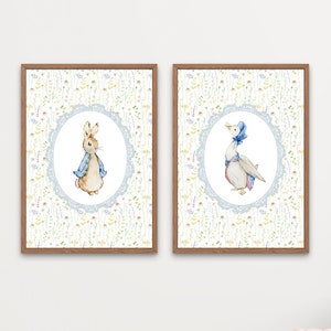 May include: Two framed watercolour prints featuring Peter Rabbit and a goose, set against a floral background. The prints are in brown wooden frames and are displayed in a child's room with a light blue chair and a toy basket.