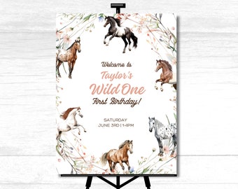 May include: Welcome to Taylor's Wild One First Birthday! A white sign with a floral border and watercolour illustrations of horses. The text reads "Welcome to Taylor's Wild One First Birthday!" and "Saturday June 3rd | 1-4PM".