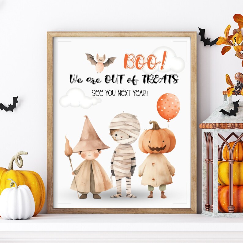 May include: A printable sign with a white background and a brown wooden frame. The sign says "BOO! We are out of treats. See you next year!" and features a cartoon witch, mummy, and pumpkin.
