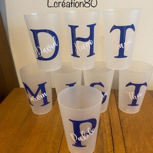 May include: Seven clear plastic cups with blue letters and white names on them. The names are David, Hugo, Tiago, Marvin, Pablo, Lisa, and Theo.