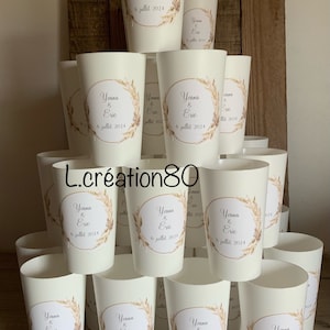 Puede incluir: Una pila de vasos desechables blancos con un diseño dorado y marrón con los nombres "Yoana & Eric" y la fecha "6 de julio de 2024".