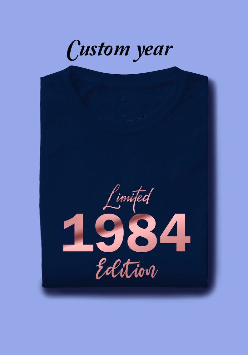 May include: A navy blue t-shirt with a rose gold design that says "Limited 1984 Edition".