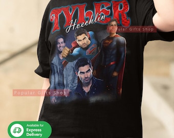 May include: Black t-shirt with a red and blue graphic print of Tyler Hoechlin as Superman and other characters. The text "Tyler Hoechlin" is printed in white on the shirt. The text "Popular Gifts Shop" is printed in white on the shirt.