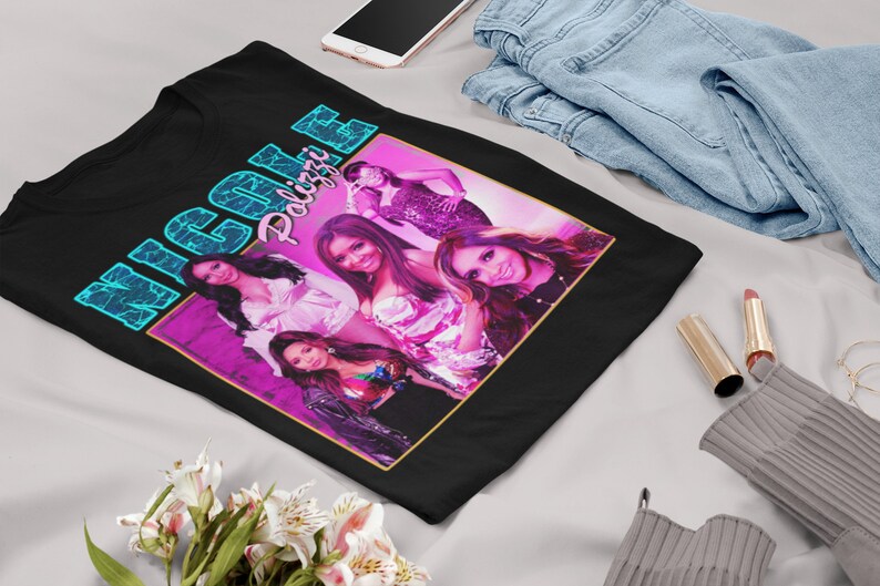 May include: Black t-shirt with a retro-style graphic of the girl group "Nicole Polizzi" in a pink and blue color scheme.