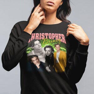 May include: Black sweatshirt with a graphic print of four men's faces. The text "CHRISTOPHER Briney" is printed in pink and yellow letters.