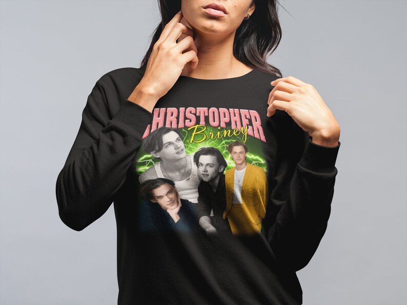 May include: Black sweatshirt with a graphic print of four men's faces. The text "CHRISTOPHER Briney" is printed in pink and yellow letters.