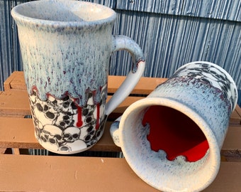 Skull Mug 16 oz. White porcelain mug with skull decoration and a bloody blue drip glaze. Deep red glaze interior.