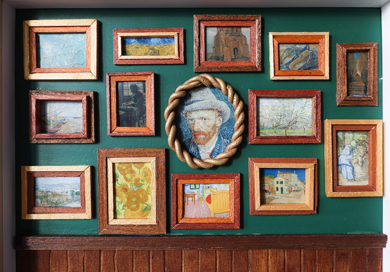 May include: A green wall with a collection of framed artwork, including a self-portrait of Vincent van Gogh, landscapes, and still lifes.