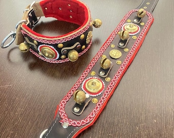 Puede incluir: Un collar de cuero negro y una correa larga a juego, ambos forrados con fieltro rojo. Los artículos presentan cascabeles de latón, placas circulares de latón y un adorno trenzado rojo y blanco. El collar incluye una anilla en D.