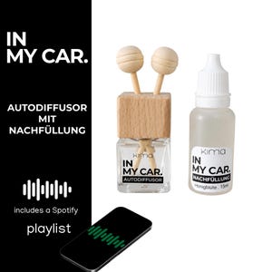 Könnte beinhalten: Ein Autodiffusor-Set bestehend aus einem quadratischen Glasflakon mit Holzverschluss und zwei Holzstäbchen sowie einer 15ml Nachfüllflasche. Beide Flaschen tragen die Aufschrift IN MY CAR. Ein schwarzes Smartphone mit grüner Schallwelle liegt bei.