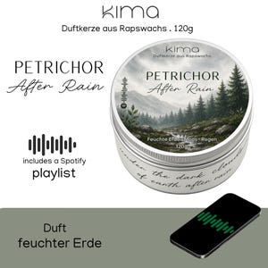 Op de afbeelding: Een ronde metalen blik met Kima koolzaadwaskaars, 120g, voorzien van een etiket met een boslandschap, de tekst PETRICHOR After Rain en een Spotify-code. De zijkant van het blik bevat de tekst under the dark clouds of earth after rain.