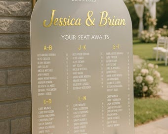 Könnte beinhalten: Ein bogenförmiges Hochzeitssitzplan-Schild aus mattiertem Acryl mit goldener Schrift "Jessica & Brian" und "YOUR SEAT AWAITS" über Namenslisten, die nach Buchstaben sortiert sind. Das Schild ist mit hellrosa Rosen und grünem Blattwerk verziert.