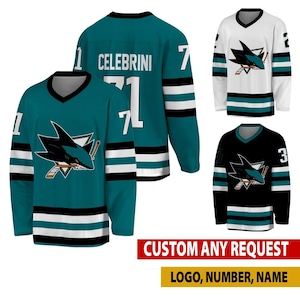 May include: A collection of three hockey jerseys in teal, white, and black, each featuring a shark logo on the chest. The teal jersey displays the name CELEBRINI and the number 71 on the back. The jerseys have striped sleeves and V-neck collars.