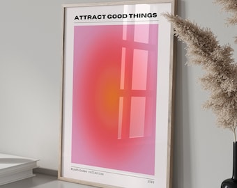 May include: A framed poster with a pink and orange gradient background and the text "ATTRACT GOOD THINGS". The poster is hanging on a wall with a white background.