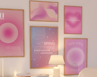 Puede incluir: Una cómoda blanca con tres cajones y pomos dorados. La cómoda tiene una tapa de mármol blanco con libros encima. Hay una silla blanca en primer plano y una pared blanca con carteles enmarcados de color rosa. Los carteles tienen texto que dice "Protege tu energía", "Aura rosa", "Trae buena energía a todas partes", y "Energía de aura rosa".