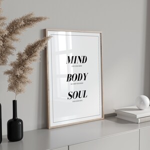 May include: A framed print with the words "MIND OPEN YOUR MIND BODY NOURISH YOUR BODY SOUL FEED YOUR SOUL" in black text on a white background.