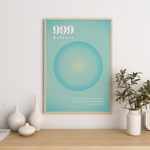 May include: A framed poster with a teal background and a large white circle in the center. The poster has the text "999 Release" and a quote about letting go of what is no longer serving you.