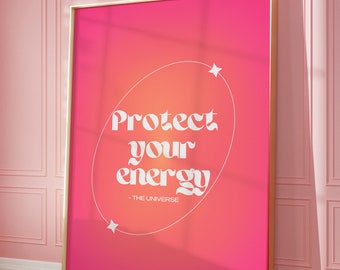 May include: A pink and orange gradient poster with a gold frame. The poster has a white circle with the text "Protect your energy - THE UNIVERSE" in a retro font. There are two white stars on the poster.