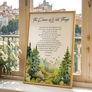 May include: A framed print featuring the poem "The Peace of Wild Things" by Wendell Berry. The artwork includes a watercolor landscape of a forest with trees, birds, and a path. The frame is gold-colored, and the print is displayed near a window.