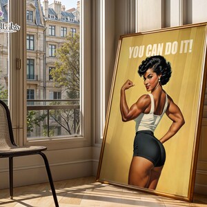 May include: A framed poster featuring a muscular person with dark hair in a white tank top and black shorts, posing with a flexed arm. The background is a solid yellow with the white text YOU CAN DO IT! printed at the top of the rectangular artwork.