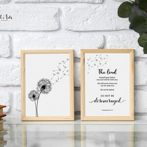 May include: Two framed prints with a white background. The print on the left features a black and white illustration of a dandelion with seeds blowing in the wind. The print on the right features a black and white text quote: "The Lord himself goes before you and will be with you. He will never leave you nor forsake you. Do not be afraid. Do not be discouraged." - Deuteronomy 31:8