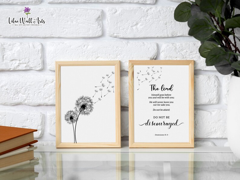 May include: Two framed prints with a white background. The print on the left features a black and white illustration of a dandelion with seeds blowing in the wind. The print on the right features a black and white text quote: "The Lord himself goes before you and will be with you. He will never leave you nor forsake you. Do not be afraid. Do not be discouraged." - Deuteronomy 31:8