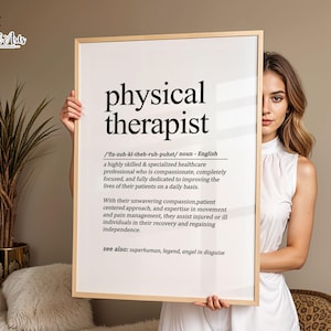 May include: A rectangular framed wall art print featuring the black text definition of physical therapist, including phonetic spelling, a descriptive paragraph about healthcare professionals, and a see also section at the bottom.