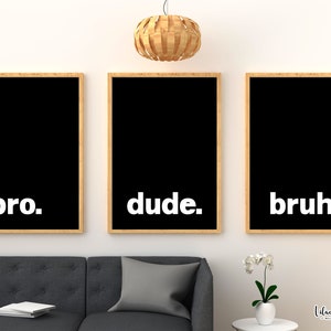 May include: Three black framed prints with white text on a white wall. The prints read "bro." "dude." and "bruh."