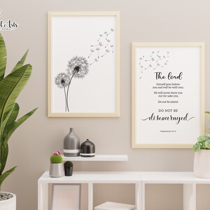 May include: Two framed prints with a white background. The print on the left features a black and white illustration of a dandelion with seeds blowing in the wind. The print on the right features a black and white text quote from Deuteronomy 31:8, "The Lord himself goes before you and will be with you. He will never leave you nor forsake you. Do not be afraid. Do not be discouraged."