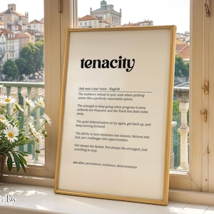 May include: A framed wall art print featuring the definition of the word tenacity in black text on a cream background. The text includes phonetic spelling, a noun classification, and several descriptive sentences about persistence and determination.
